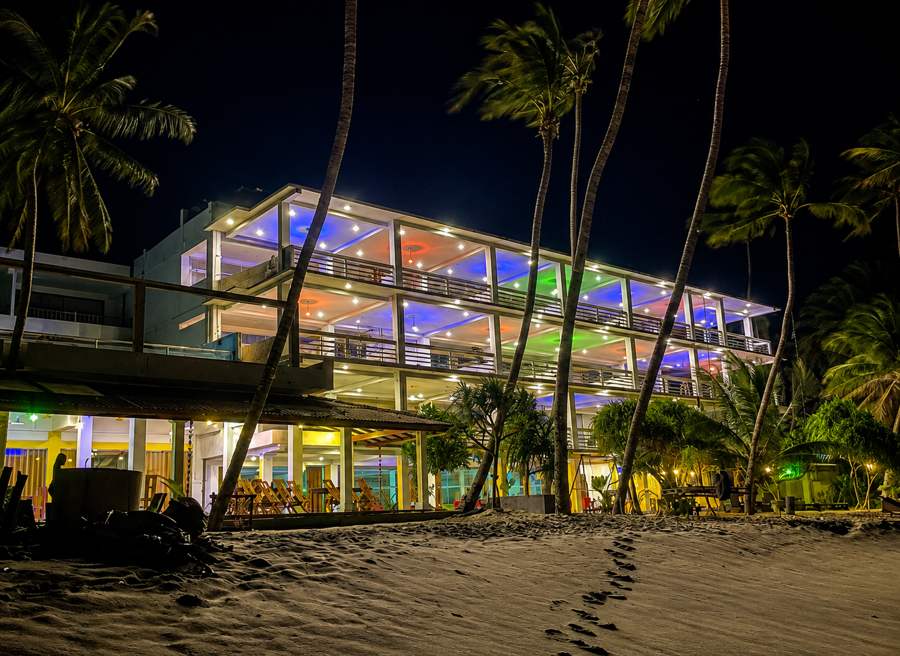 The hotel lit up in the evening seen from the beach