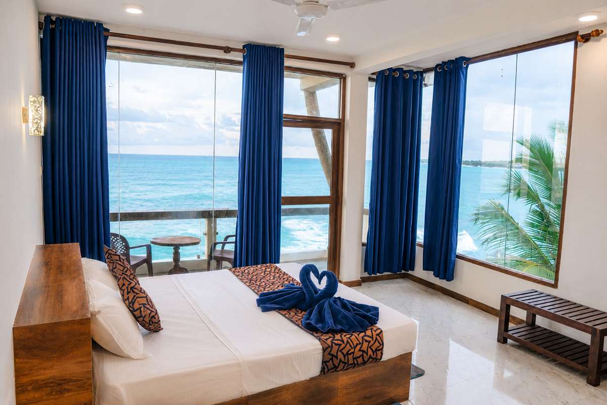 Ocean-view guest room with a wide balcony over the water
